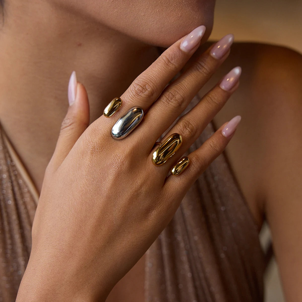 Mão feminina com anéis tendência mix em aço inoxidável nas cores dourado e prata, estilo moderno e elegante CIDEIVAN