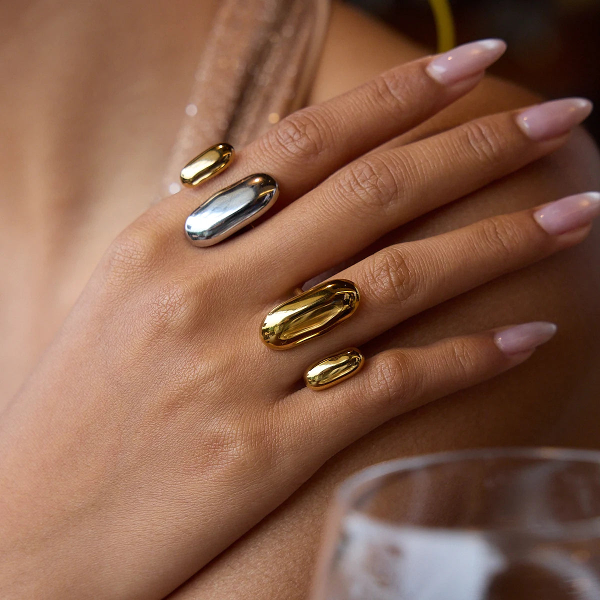 Mão feminina usando anel tendência mix em aço inoxidável dourado e prateado com design moderno e elegante CIDEIVAN