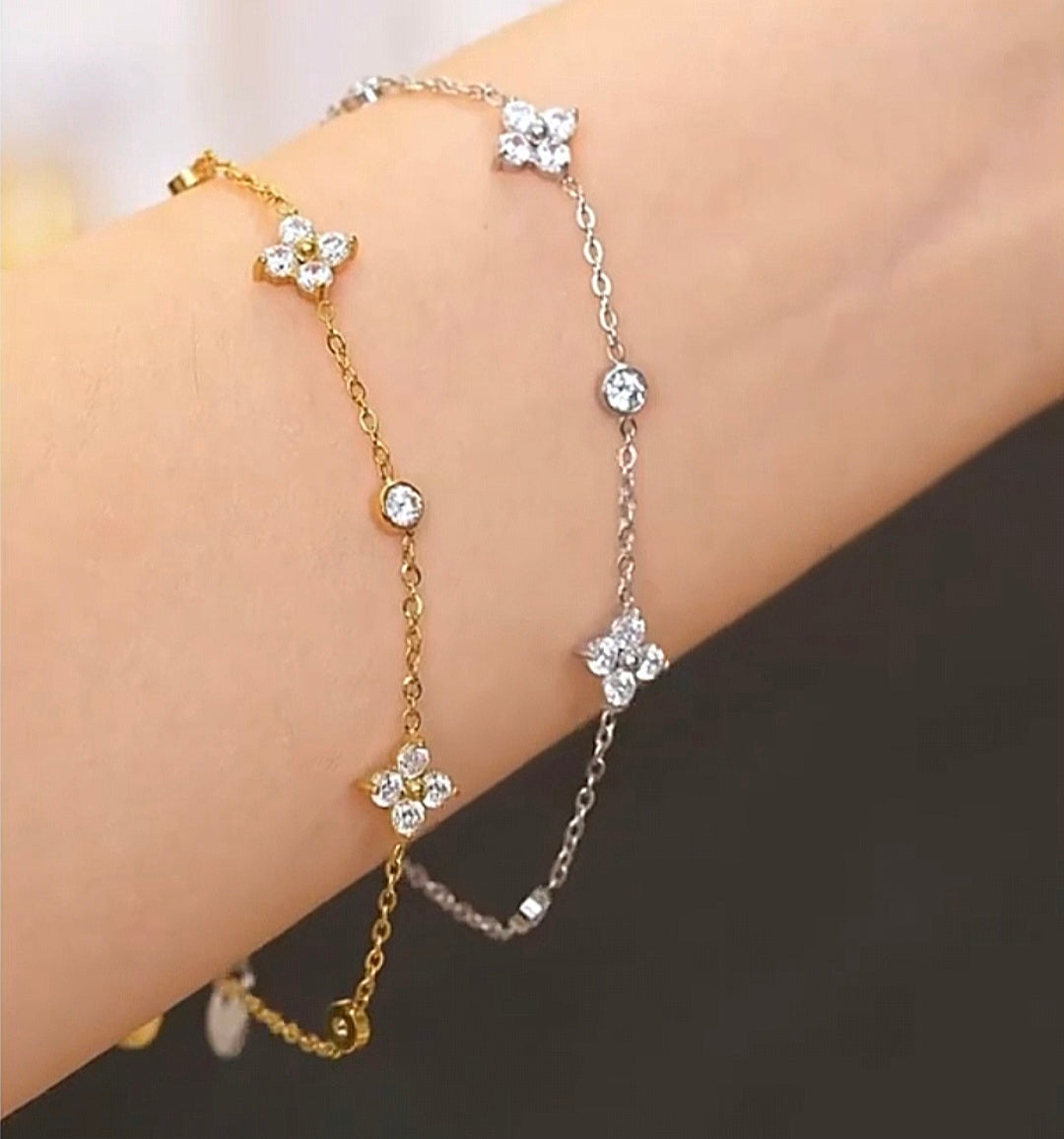 Pulseira flor de zircônia em aço inox com banho ouro e prata, delicada e elegante para ocasiões especiais.