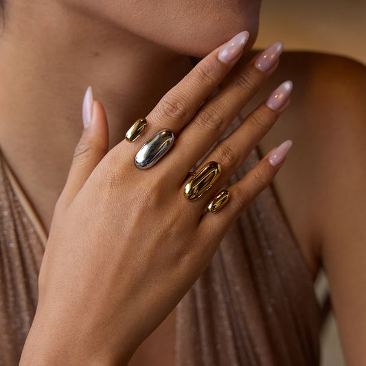 Mão feminina com anéis tendência mix em aço inoxidável nas cores dourado e prata, estilo moderno e elegante CIDEIVAN